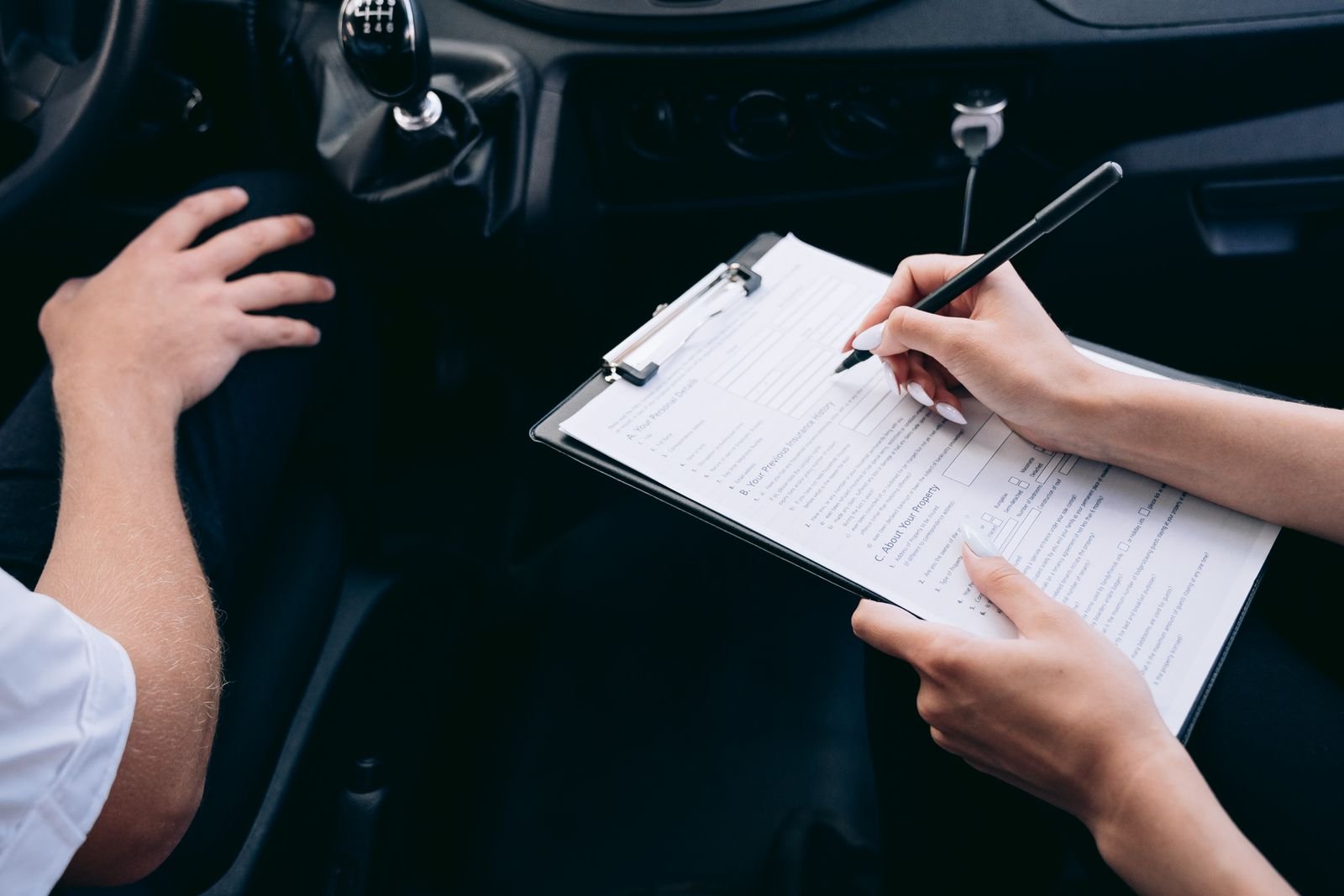 Automobiliste remplissant un document au volant de sa voiture