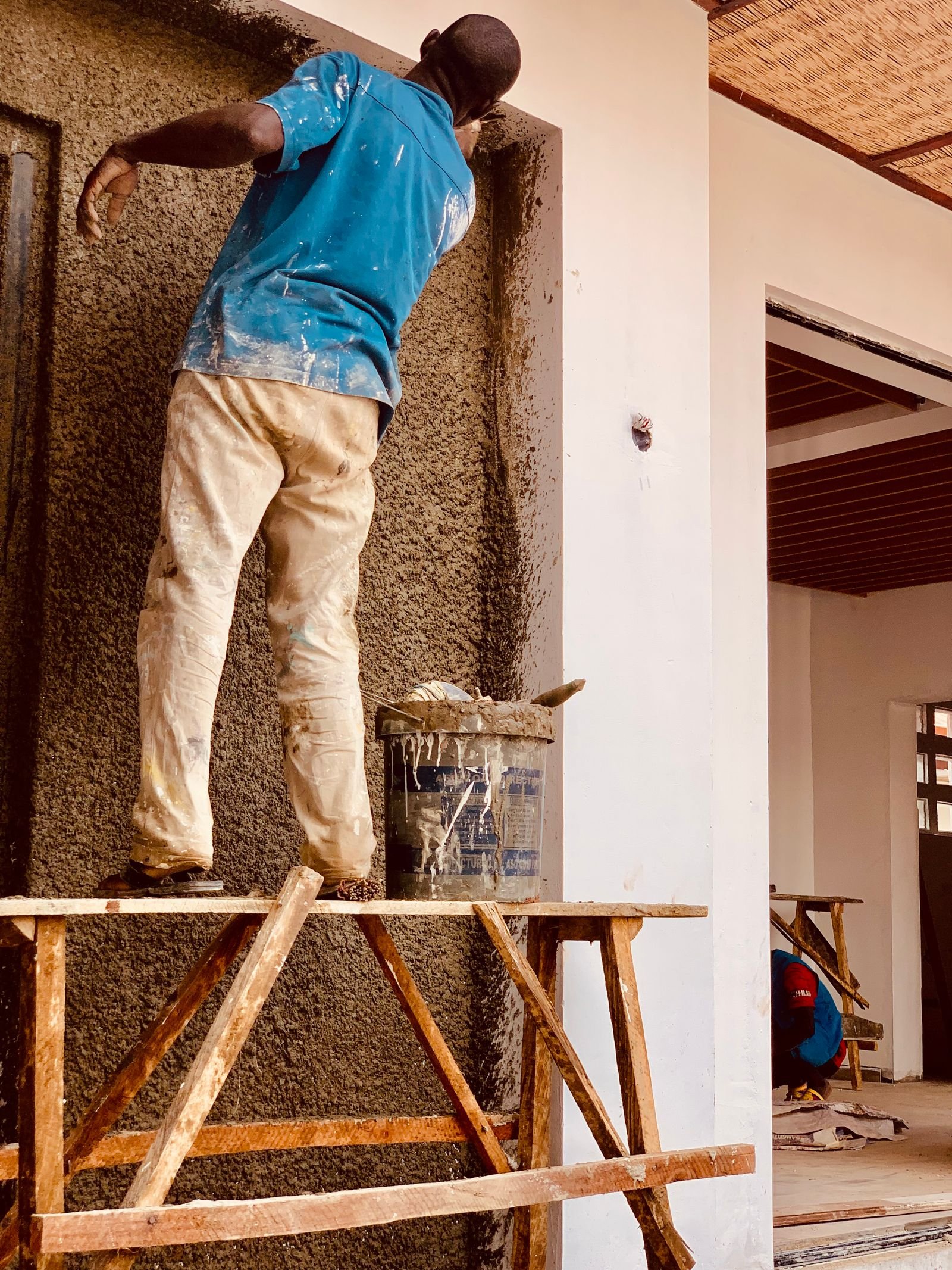 Artisan appliquant un enduit sur un mur