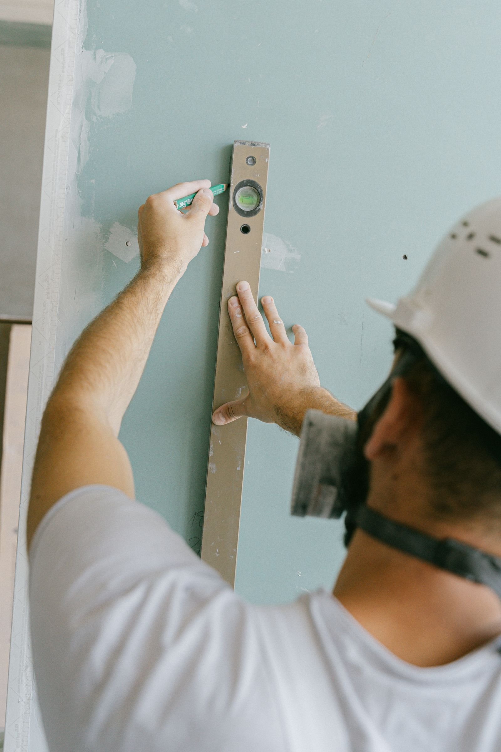 Artisan du bâtiment vérifiant le niveau d'un mur sur un chantier